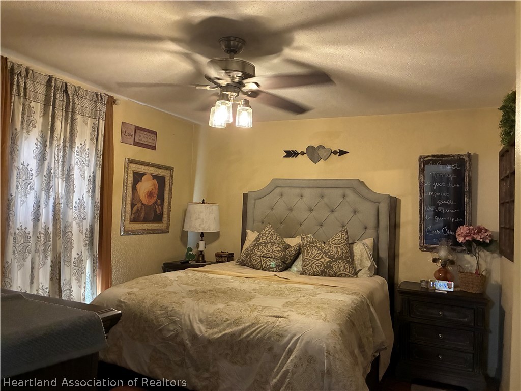 922 Breezy Road Lake Placid, FL 33852 - Photo 11 of 18 a bedroom with a bed and a chandelier