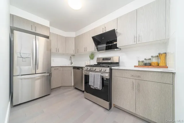 a kitchen with stainless steel appliances white cabinets and a refrigerator