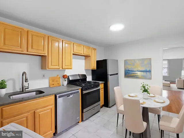 a kitchen with stainless steel appliances a stove a sink a microwave a refrigerator and cabinets