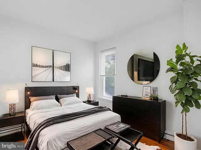 a bedroom with a bed and a potted plant