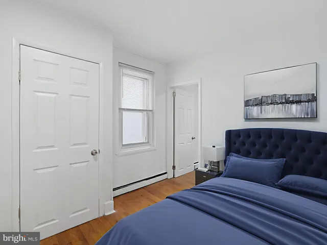 a bedroom with a bed and a painting on the wall