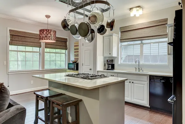 a kitchen with a stove a sink a chandelier and dining table
