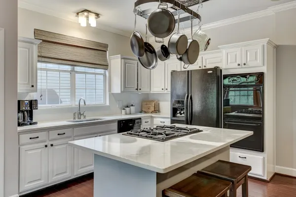 a kitchen with a table a sink cabinets and stainless steel appliances
