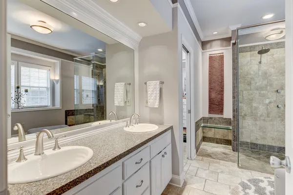 a bathroom with a granite countertop sink a mirror and a shower