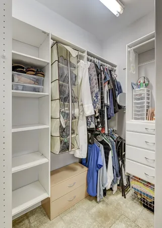 a view of walk in closet with clothes and shoes