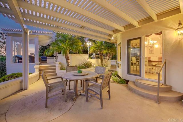 a view of a patio with dining table and chairs with a barbeque grill and plants