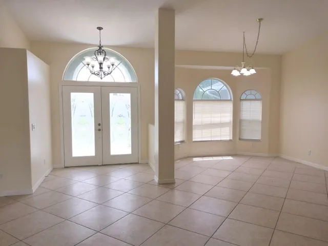 a view of a livingroom with a chandelier a kitchen area and chandelier