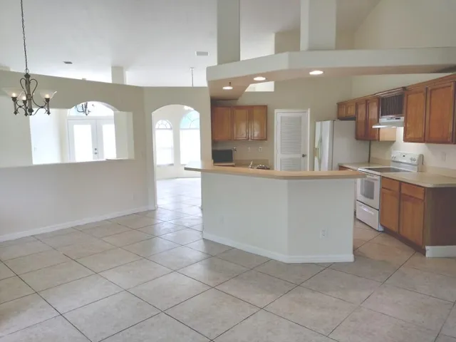 a large kitchen with kitchen island a sink stainless steel appliances and cabinets