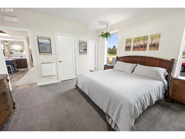 a bedroom with a large bed a flat tv screen and dresser