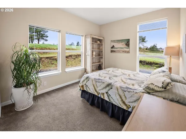 a bedroom with a bed and a large window