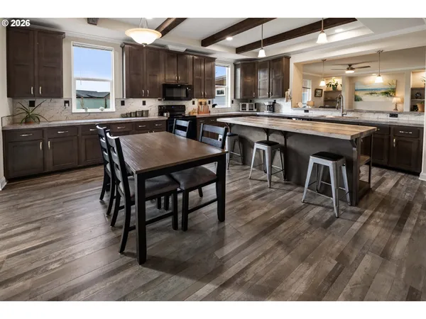 a kitchen with lots of wooden furniture appliances and cabinets
