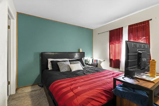 a bedroom with a bed and a flat screen tv