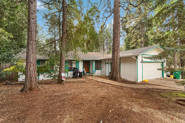 a view of a house with backyard and sitting area