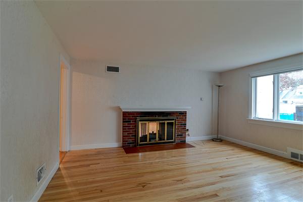 22 Stratford Road Natick, MA 01760 - Photo 2 of 18 a view of an empty room with wooden floor and a window