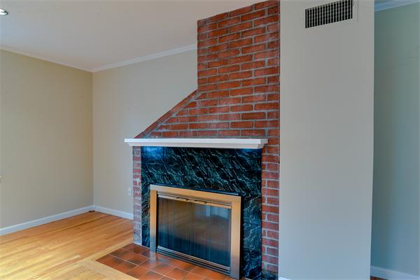22 Stratford Road Natick, MA 01760 - Photo 4 of 18 a view of an empty room with wooden floor and a fireplace