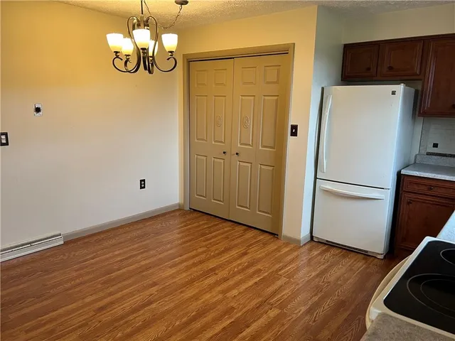 a view of a kitchen with wooden floor and a refrigerator