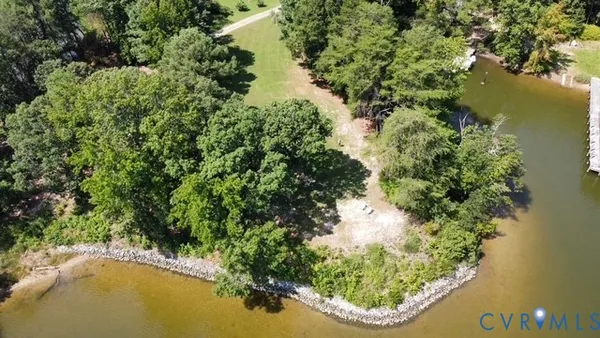 an aerial view of a house with a yard and lake view