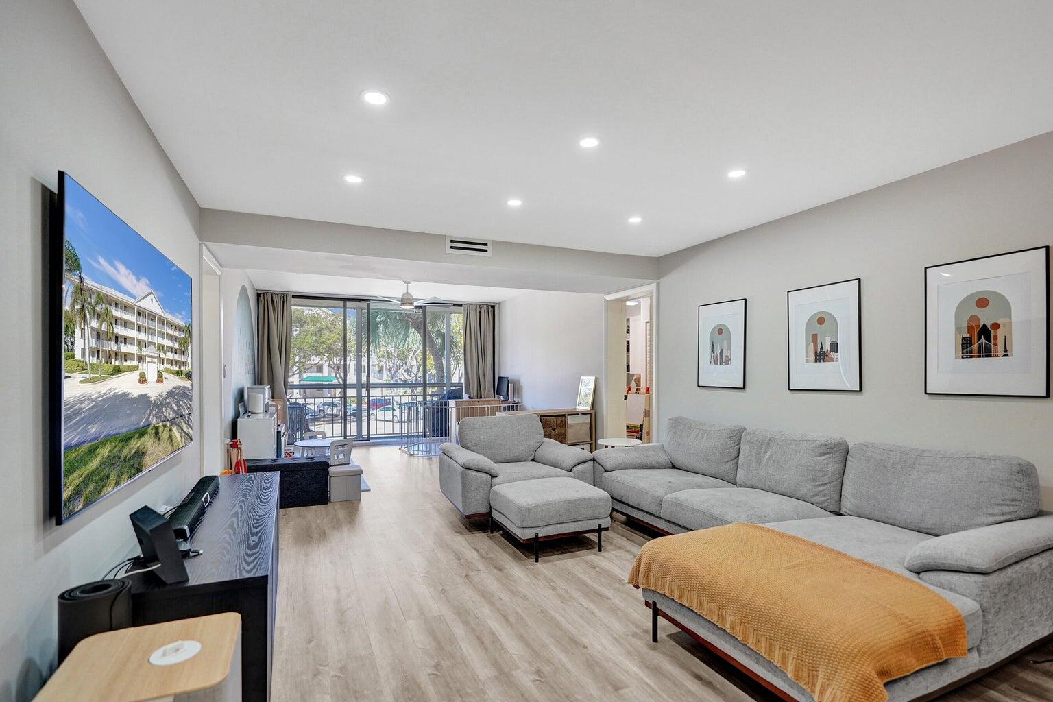 6193 Balboa Circle, Unit 201 Boca Raton, FL 33433 - Photo 20 of 62 a living room with furniture flat screen tv and large windows