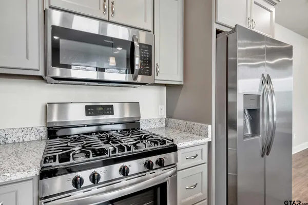 a kitchen with stainless steel appliances granite countertop a stove and a microwave