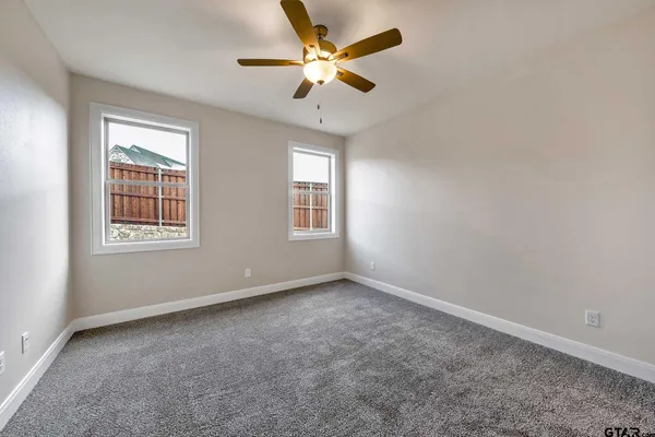 an empty room with a window and a fan