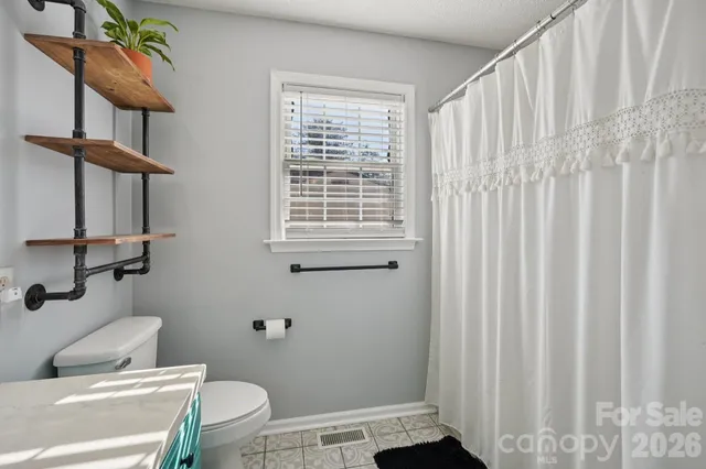 a bathroom with a toilet and a shower curtain