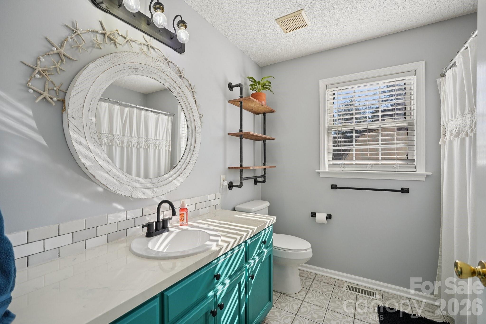 3802 Babe Lane Vale, NC 28168 - Photo 15 of 27 a bathroom with a granite countertop toilet a sink and a mirror