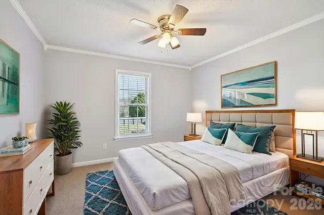 a bedroom with a large bed and a chandelier