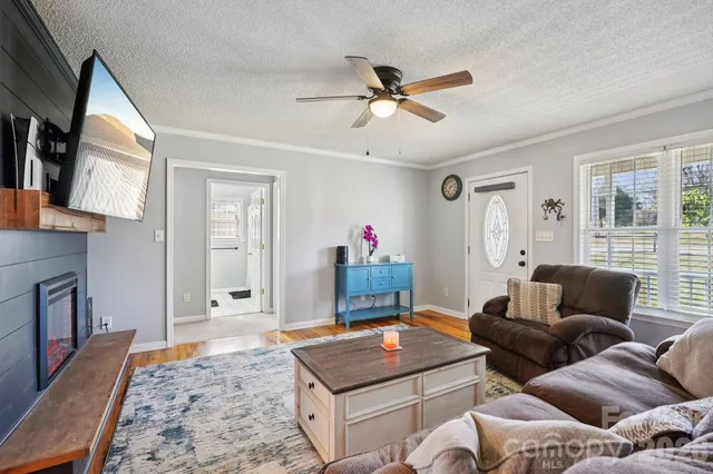 a living room with furniture a flat screen tv and a window