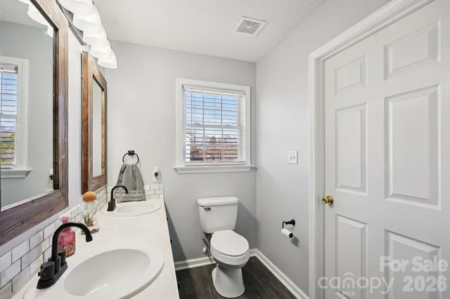 a bathroom with a sink a toilet and a mirror