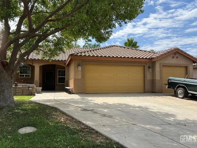 a front view of a house with a garden and yard
