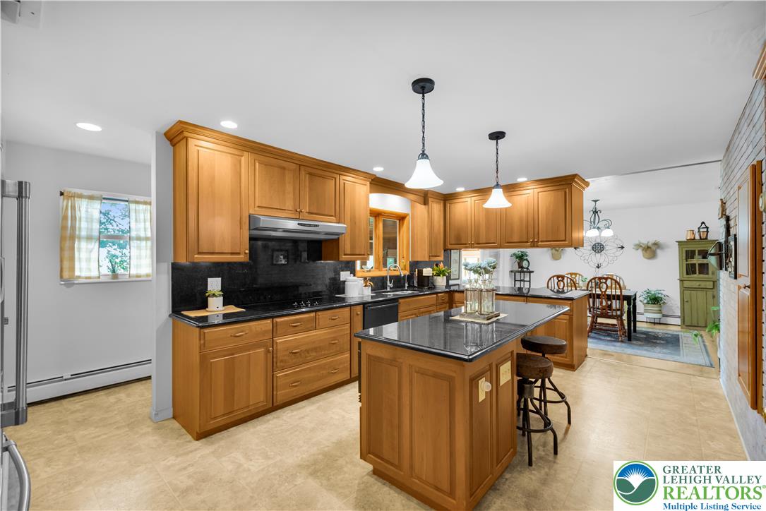 5747 Kernsville Road Orefield, PA 18069 - Photo 13 of 56 a kitchen with stainless steel appliances granite countertop a sink a stove top oven a counter space and cabinets