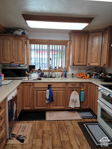 97 East Main Street Stockton, UT 84071 - Photo 37 of 58 Kitchen with stainless steel microwave, range with two ovens, light wood-style floors, and light countertops