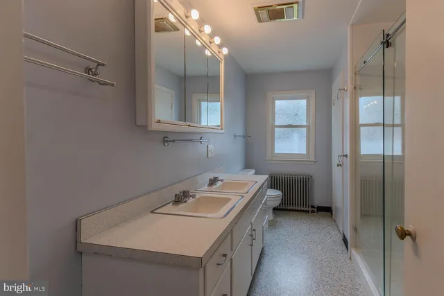 a bathroom with a sink a toilet and shower