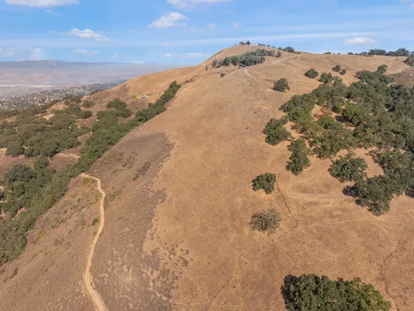 a view of a dry yard with mountains in the background