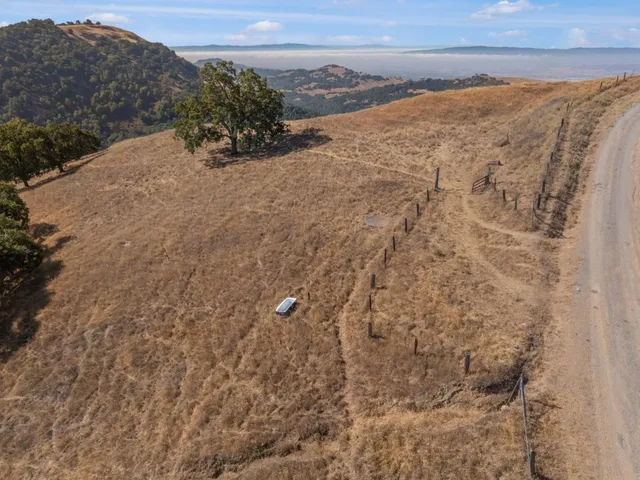 a view of a dry yard with mountains in the background
