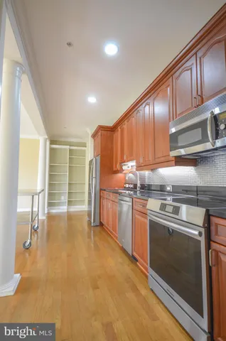 a kitchen with stainless steel appliances granite countertop a stove a sink and a microwave