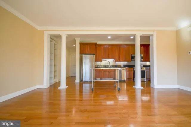 a room with wooden floor and a view of living room