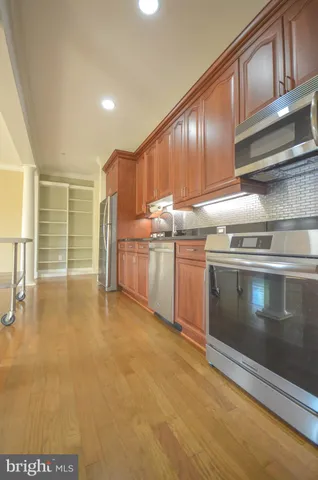 a kitchen with stainless steel appliances granite countertop a stove a sink and a refrigerator