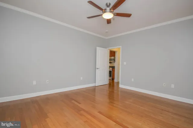 an empty room with closet and a ceiling fan