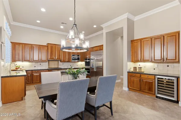 a view of a dining room with furniture a kitchen and chandelier