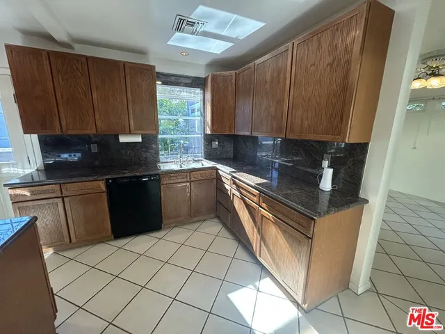 a kitchen with a sink a stove top oven a refrigerator and cabinets