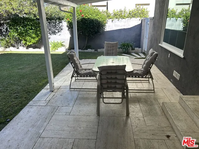 a view of a patio with table and chairs and potted plants