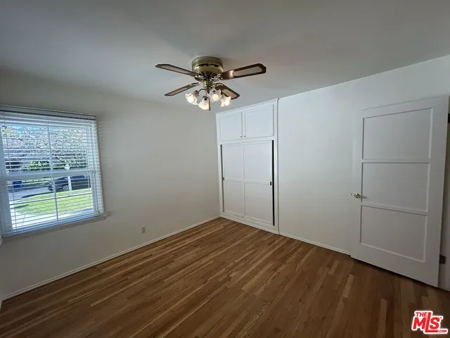 a view of room with hardwood floor and ceiling fan