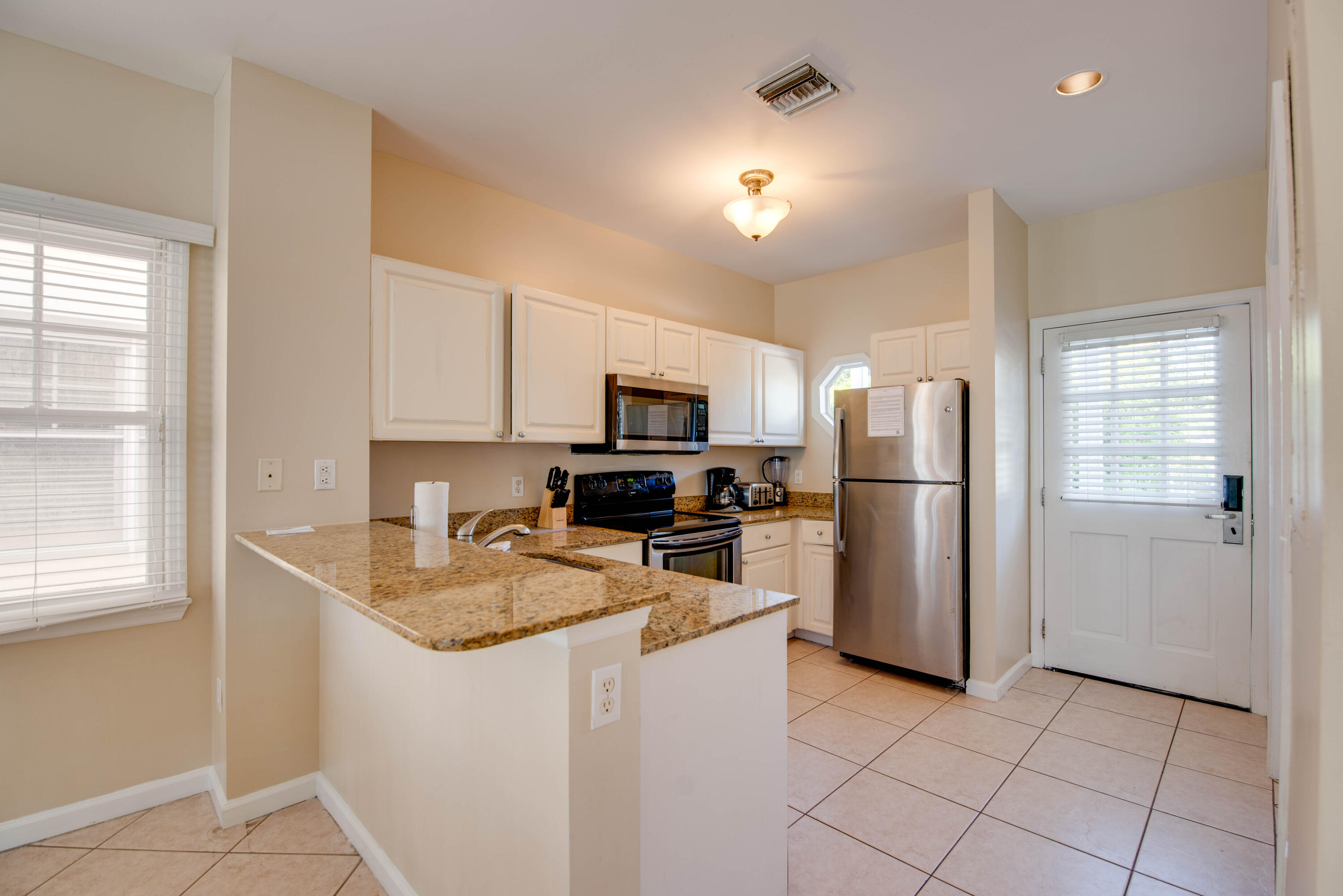 7073 Hawks Cay Boulevard Marathon, FL 33050 - Photo 10 of 50 a kitchen with a refrigerator a microwave a sink and cabinets