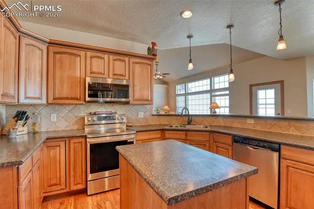 a kitchen with stainless steel appliances granite countertop a sink stove and microwave