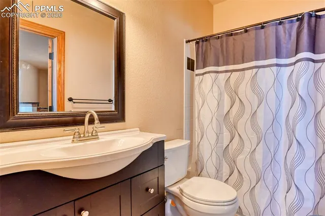 a bathroom with a sink a toilet and shower curtain