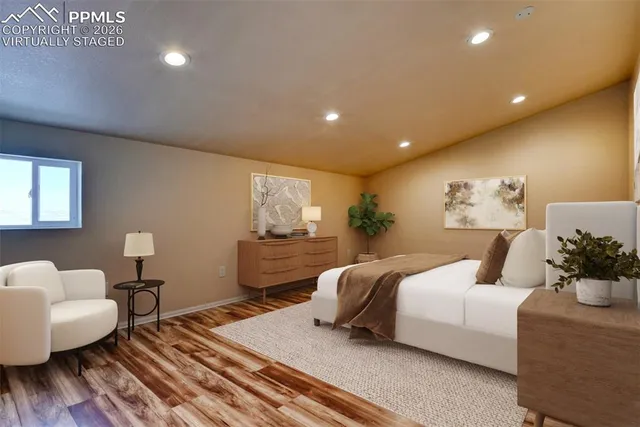 a spacious bedroom with a bed and wooden floor