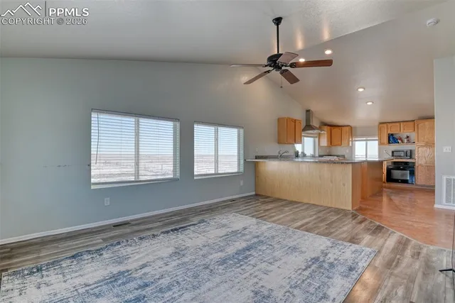 a view of a kitchen with furniture and wooden floor