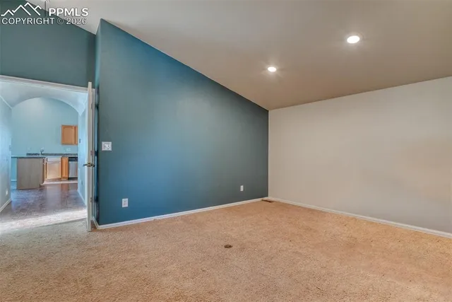 an empty room with wooden floor and entrance