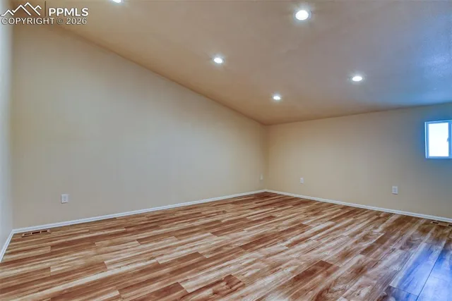 a view of empty room with wooden floor